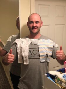 Carl holding premature baby clothes